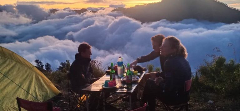 Hikers having a meal at their camp, on the trail up Mt. Rinjani