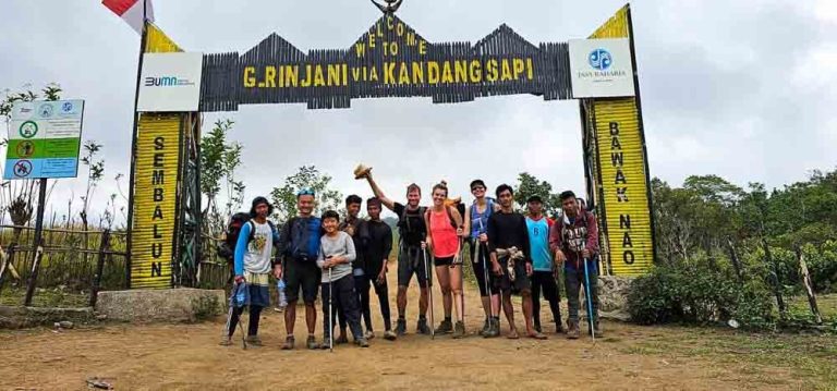 A group of hikers and their guide at the Sembalun entrance, along their Mt. Rinjani hike.