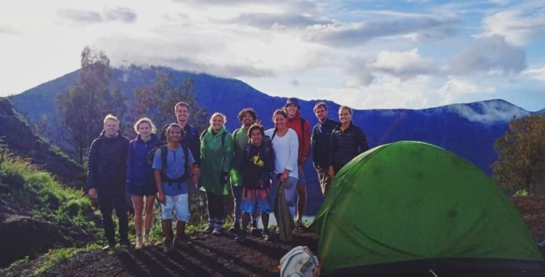 A group of hikers outside their basecamp tent, on the slopes of Mt. Rinjani