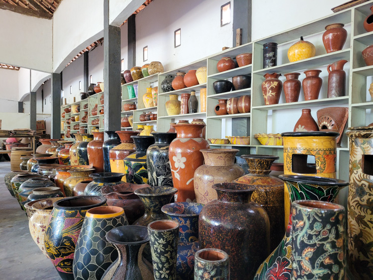 A colorful collection of traditional handmade pottery on display inside a workshop in Lombok, where visitors can admire the craftsmanship of local artisans, often as part of a cultural experience that complements the adventure of a Mt. Rinjani hike across the island.